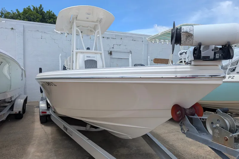 Slide: The Image of 2021 Pathfinder 2500 Hybrid boat on trailer, parked outdoors, clear sky background. - 7