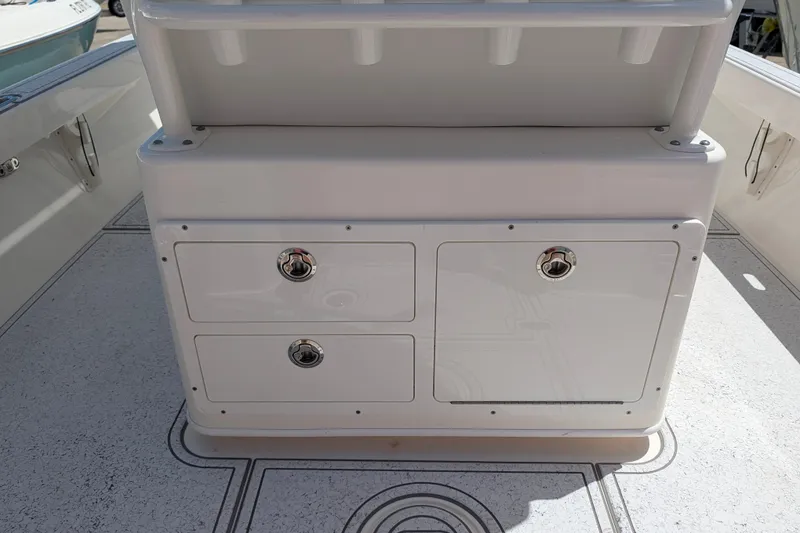 Slide: The Image of 2021 Pathfinder 2500 Hybrid boat storage compartment with rod holders on deck. - 24