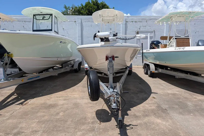Slide: The Image of 2021 Pathfinder 2500 Hybrid boat on trailer, flanked by two other boats, outdoors. - 6