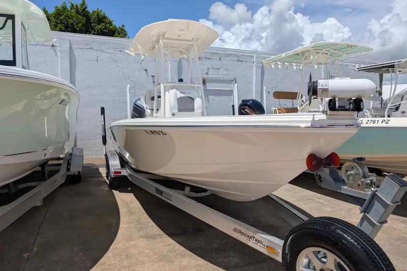 Slide: The Image of 2021 Pathfinder 2500 Hybrid boat on trailer, parked outdoors under a cloudy sky. - 5