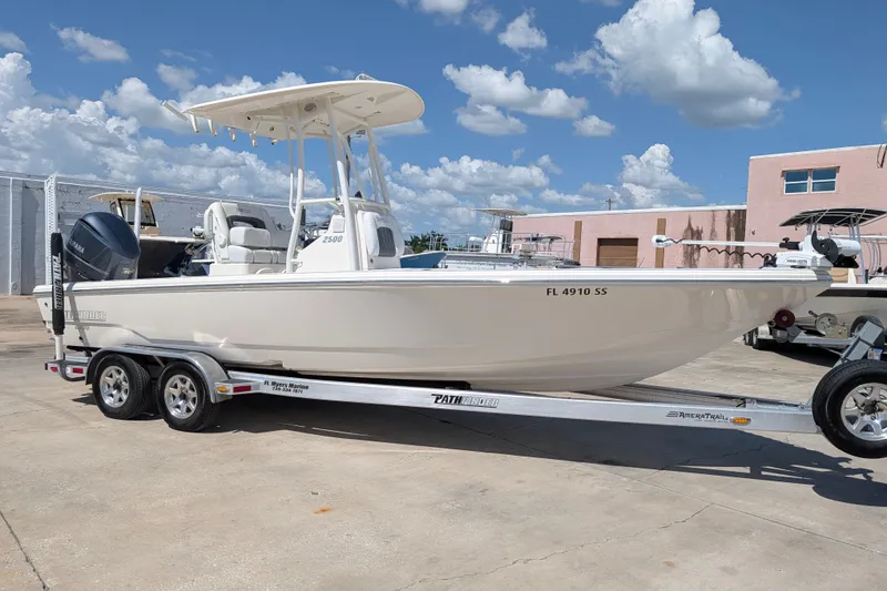 The Image of 2021 Pathfinder 2500 Hybrid boat on trailer, parked outdoors under a blue sky. - 0