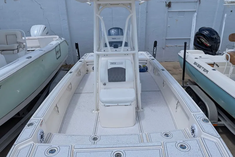 Slide: The Image of 2021 Pathfinder 2500 Hybrid boat with center console and seating, docked alongside other boats. - 44