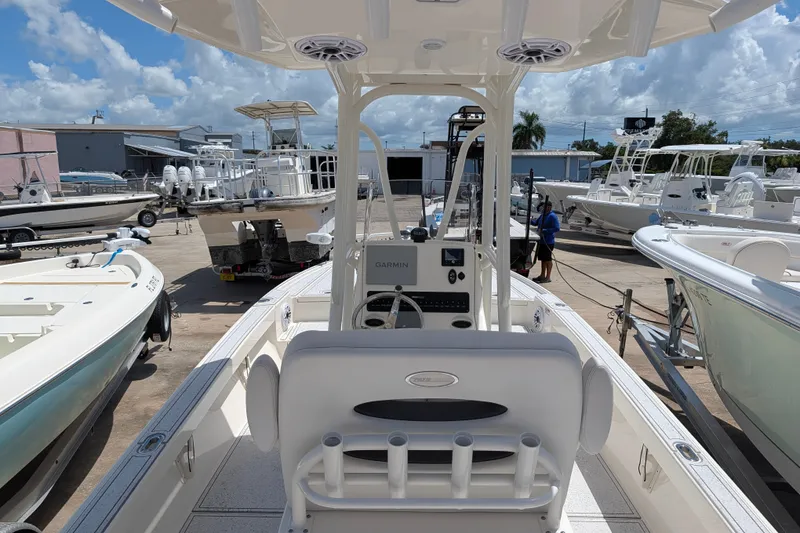 Slide: The Image of 2021 Pathfinder 2500 Hybrid boat interior with console and seating, docked among other boats. - 21