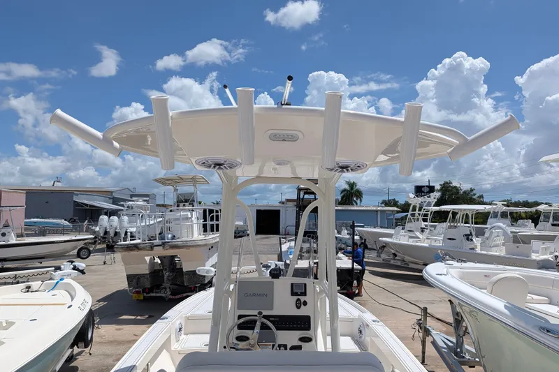 Slide: The Image of 2021 Pathfinder 2500 Hybrid boat in a sunny marina, showcasing its helm and T-top. - 23
