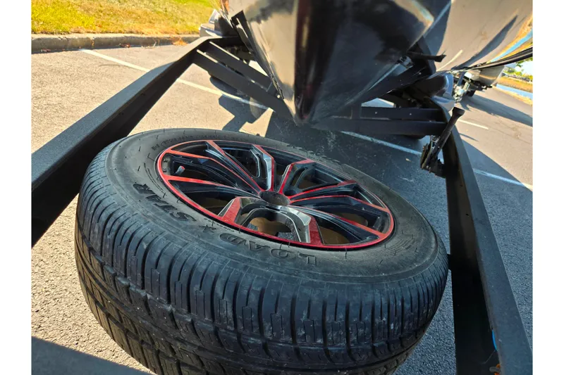 Slide: The Image of 2025 Vexus VX21 trailer with stylish red-accented wheel in a parking lot. - 3