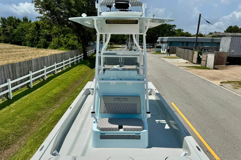 Slide: The Image of 2024 Shallow Sport 25 X3 boat on a road, showcasing sleek design and spacious deck. - 17