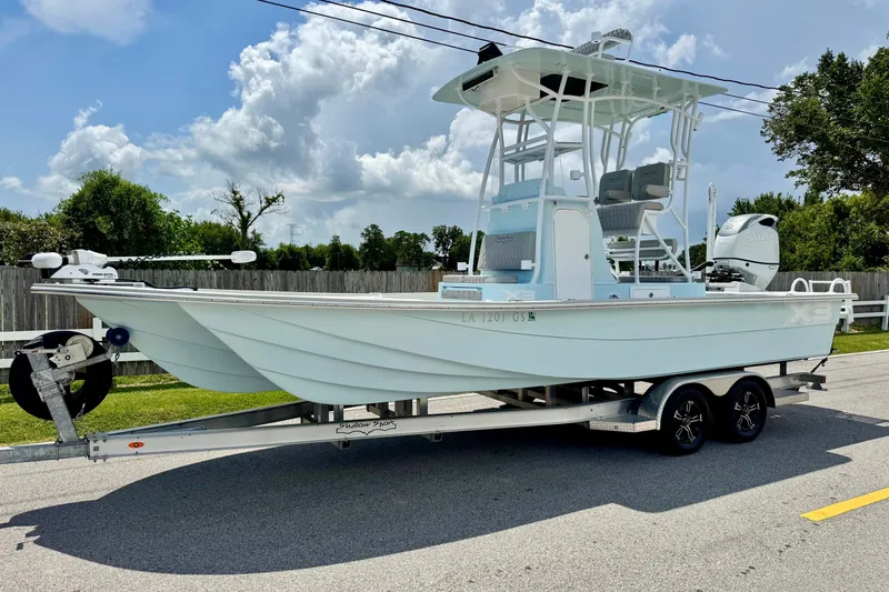The Image of 2024 Shallow Sport 25 X3 boat on trailer, parked on a sunny day. - 1