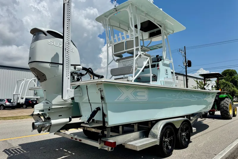Slide: The Image of 2024 Shallow Sport 25 X3 boat on trailer, featuring Suzuki outboard motor. - 4