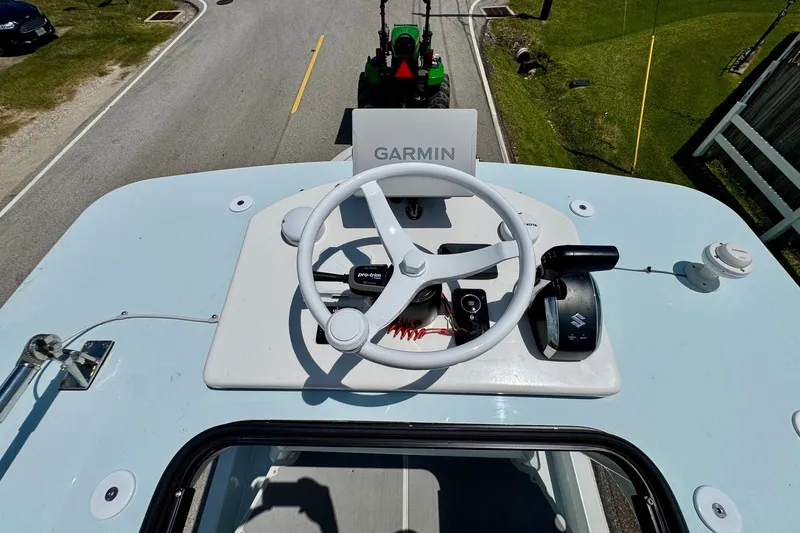 Slide: The Image of 2024 Shallow Sport 25 X3 boat helm with Garmin navigation system and Suzuki controls. - 20
