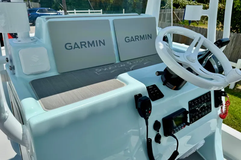 Slide: The Image of 2024 Shallow Sport 25 X3 boat dashboard with Garmin displays and steering wheel. - 18