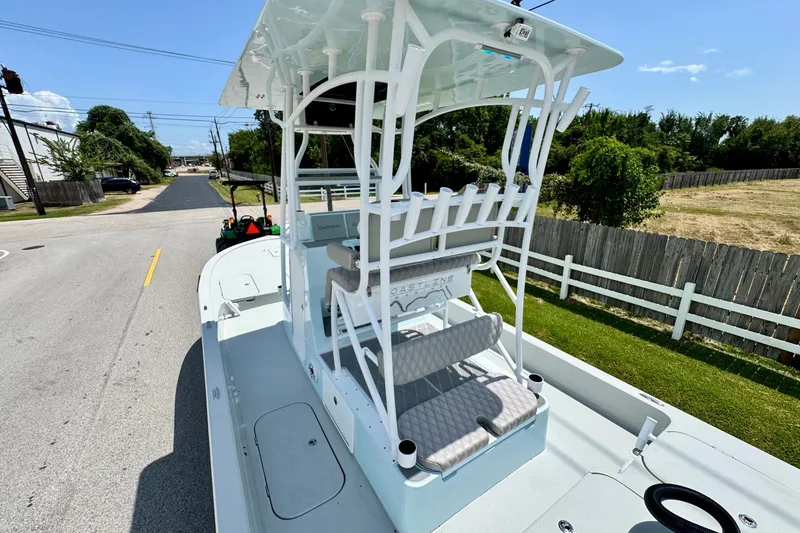 Slide: The Image of 2024 Shallow Sport 25 X3 boat on a trailer, parked on a suburban street. - 8