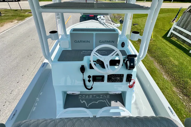 Slide: The Image of 2024 Shallow Sport 25 X3 boat dashboard with Garmin navigation system and steering wheel. - 10