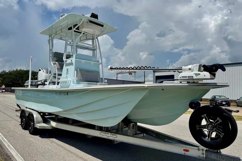 Slide: The Image of 2024 Shallow Sport 25 X3 boat on trailer, featuring Minn Kota trolling motor. - 5