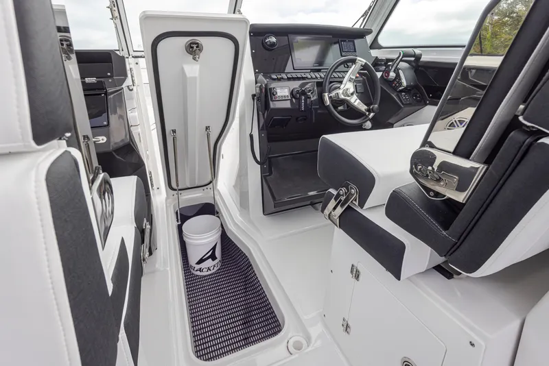 Slide: The Image of 2024 Blackfin 272 DC boat interior with helm, seating, and storage compartment. - 31