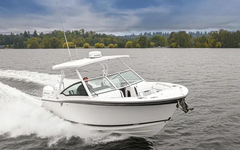 Slide: The Image of 2024 Blackfin 272 DC boat cruising on a lake with scenic background. - 8