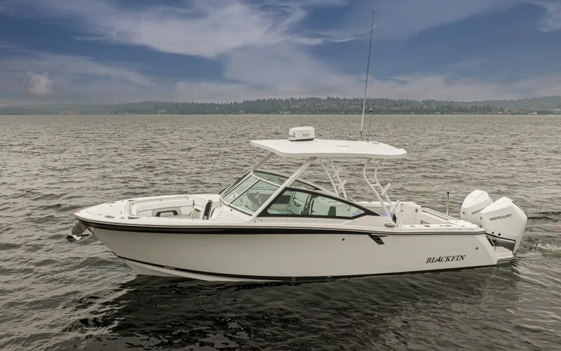 Slide: The Image of 2024 Blackfin 272 DC boat on open water under cloudy sky. - 1