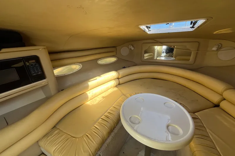 Slide: The Image of 1998 Sea Ray 280 Sun Sport cabin interior with seating and table. - 18