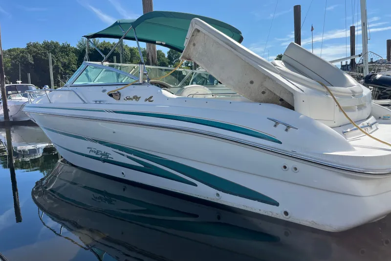 Slide: The Image of 1998 Sea Ray 280 Sun Sport boat docked, featuring teal accents and canopy. - 15