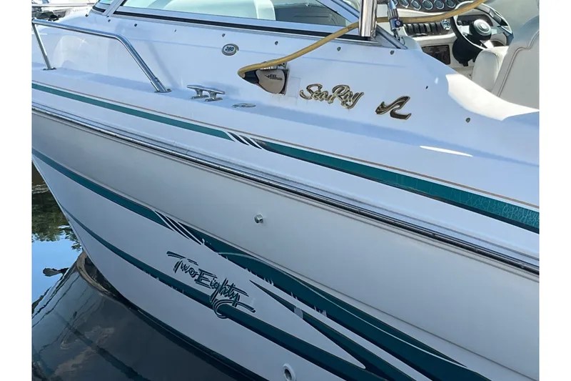 Slide: The Image of 1998 Sea Ray 280 Sun Sport boat with teal accents and sleek design. - 14