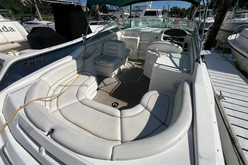 Slide: The Image of 1998 Sea Ray 280 Sun Sport boat interior with white seating and dashboard at a marina. - 8