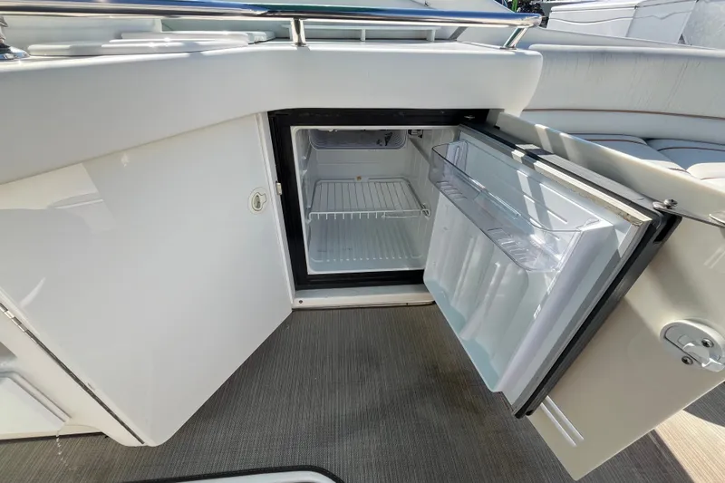 Slide: The Image of Open mini fridge on 1998 Sea Ray 280 Sun Sport boat, showcasing interior storage space. - 12