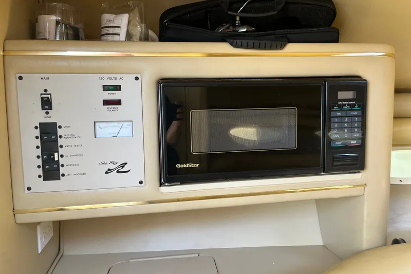 Slide: The Image of Control panel and microwave inside a 1998 Sea Ray 280 Sun Sport boat. - 19