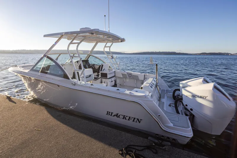 Slide: The Image of A sleek 2027 Blackfin 252 DC boat docked at a sunny pier with calm waters. - 7