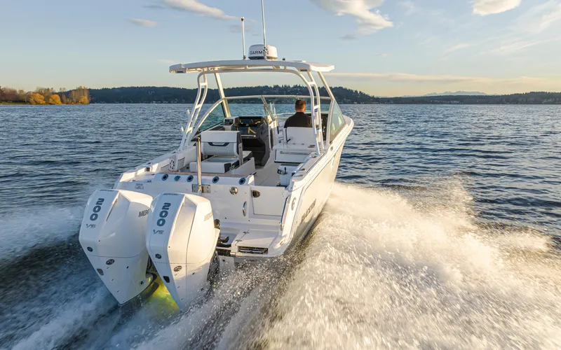 Slide: The Image of 2024 Blackfin 252 DC boat cruising on a lake with twin outboard engines. - 4