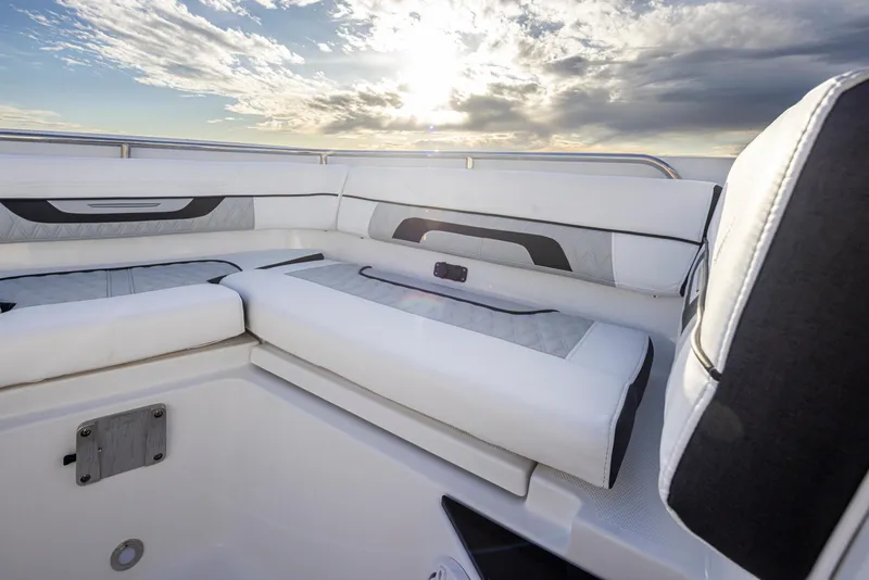Slide: The Image of 2024 Blackfin 252 DC boat interior with white and gray seating at sunset. - 12