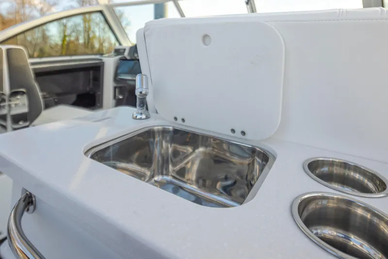 Slide: The Image of 2024 Blackfin 252 DC boat interior sink and cup holders. - 22