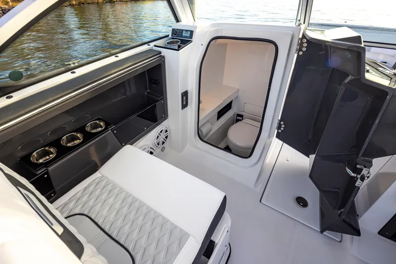 Slide: The Image of 2024 Blackfin 252 DC boat interior with seating, storage, and a compact restroom. - 24