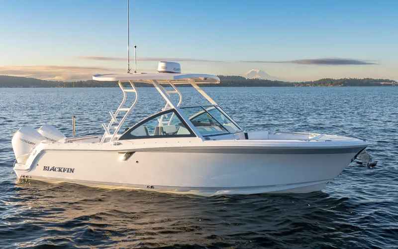 The Image of A sleek, white Blackfin 252 DC boat on calm water with a clear sky in the background. - 0
