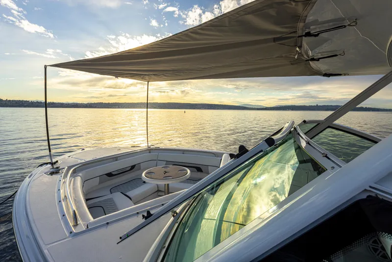 Slide: The Image of 2024 Blackfin 252 DC boat with sunshade on a serene lake at sunset. - 34