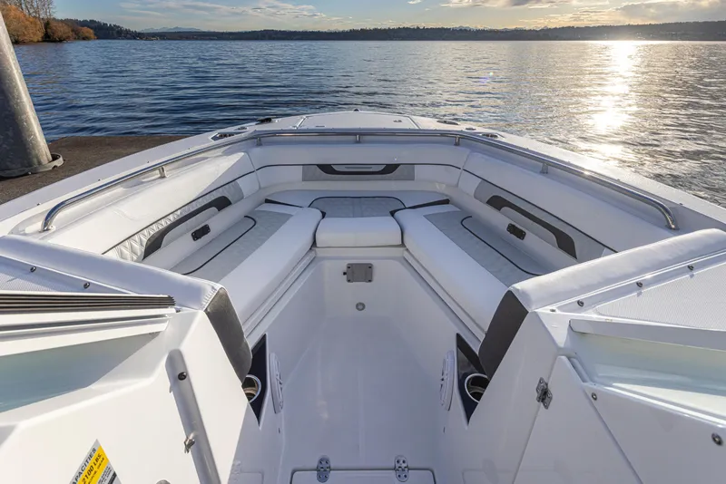 Slide: The Image of 2024 Blackfin 252 DC boat interior with white seating, docked by a serene lake. - 10