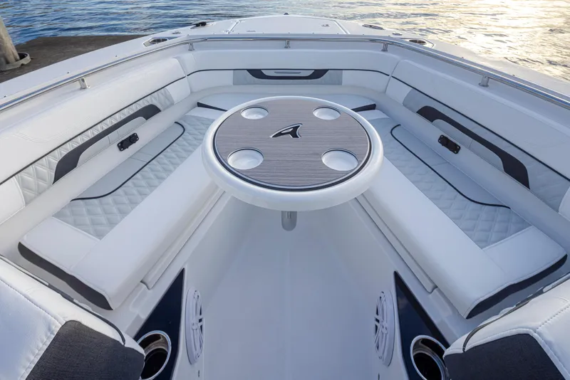 Slide: The Image of 2024 Blackfin 252 DC boat interior with white cushioned seating and round table. - 30