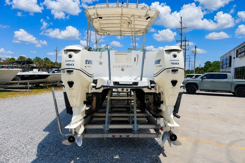 Slide: The Image of 2006 Glacier Bay 2670 Isle Runner with twin Evinrude 150 engines on a trailer. - 4