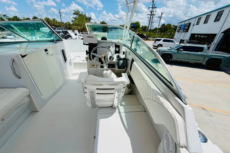 Slide: The Image of 2006 Glacier Bay 2670 Isle Runner boat interior with steering wheel and seating. - 13
