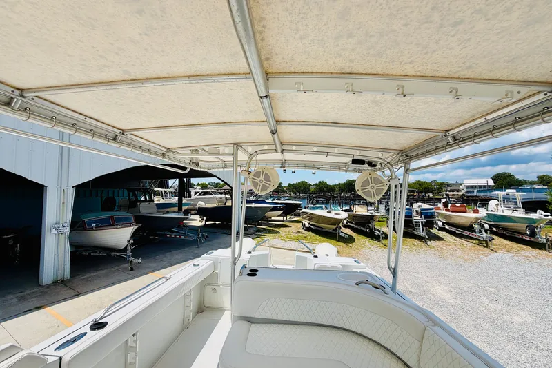 Slide: The Image of 2006 Glacier Bay 2670 Isle Runner boat interior with canopy, docked near other boats. - 17