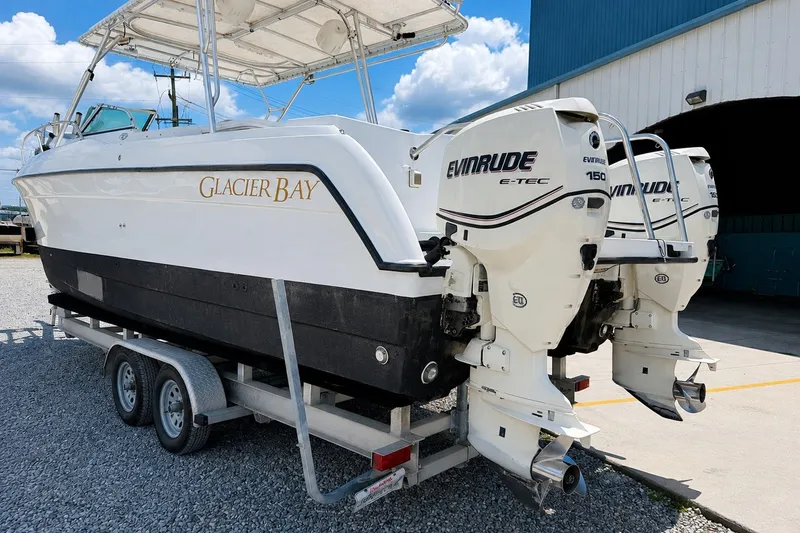 Slide: The Image of 2006 Glacier Bay 2670 Isle Runner boat on trailer with dual Evinrude engines. - 5
