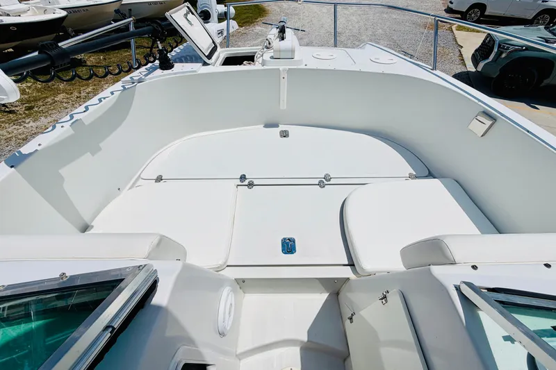 Slide: The Image of 2006 Glacier Bay 2670 Isle Runner boat interior with white seating and storage compartments. - 18