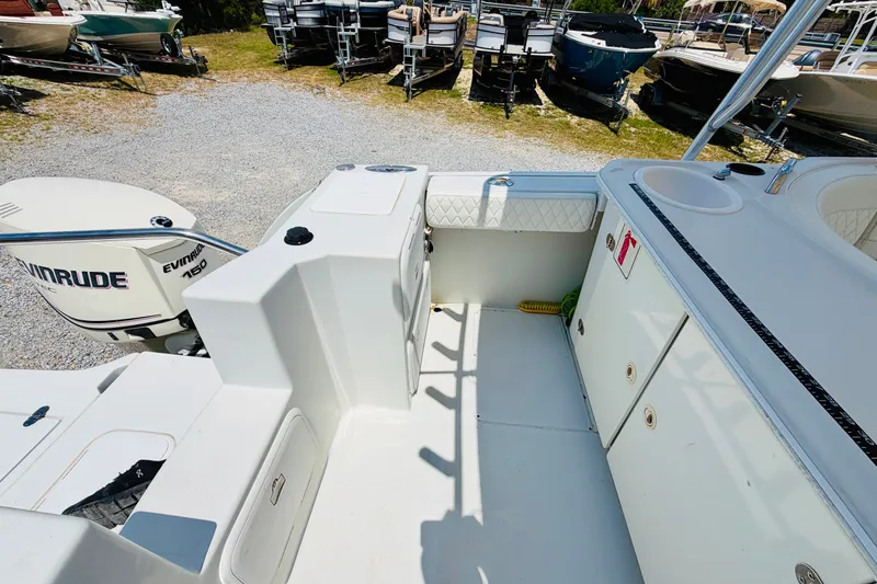 Slide: The Image of 2006 Glacier Bay 2670 Isle Runner boat interior with Evinrude engine, docked among other boats. - 9