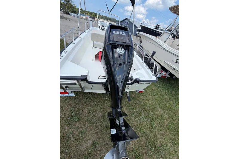 Slide: The Image of 2018 Boston Whaler 150 Montauk boat with 60 HP engine, parked on grass. - 7