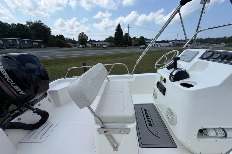 Slide: The Image of 2018 Boston Whaler 150 Montauk boat interior with Mercury engine and control panel. - 4