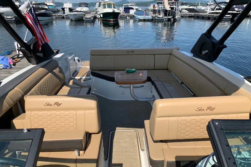 Slide: The Image of 2022 Sea Ray SDX 270 boat interior with tan seating, docked at a marina. - 16