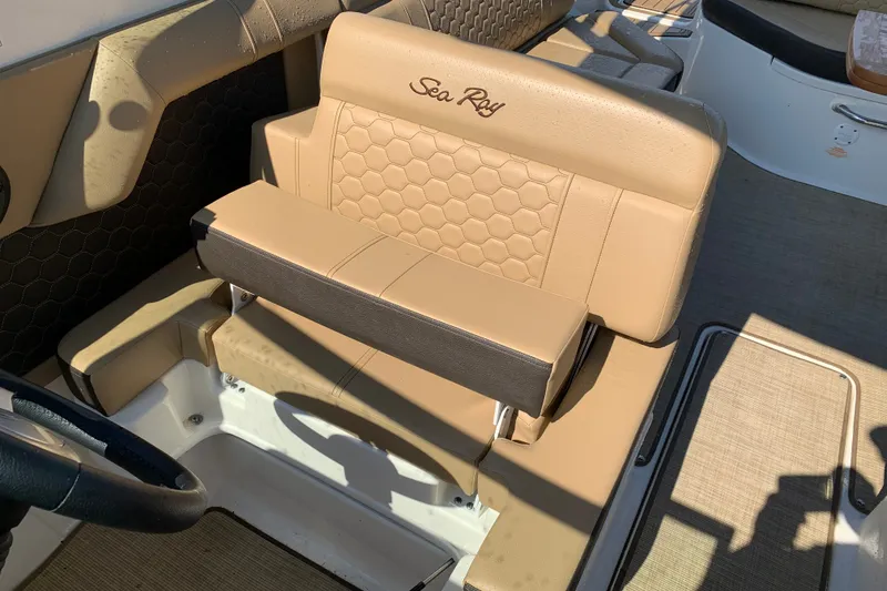 Slide: The Image of 2022 Sea Ray SDX 270 boat seat with tan upholstery and embossed logo. - 18