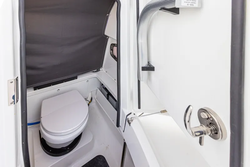 Slide: The Image of The image shows a compact boat toilet with a white seat and gray curtain. - 16