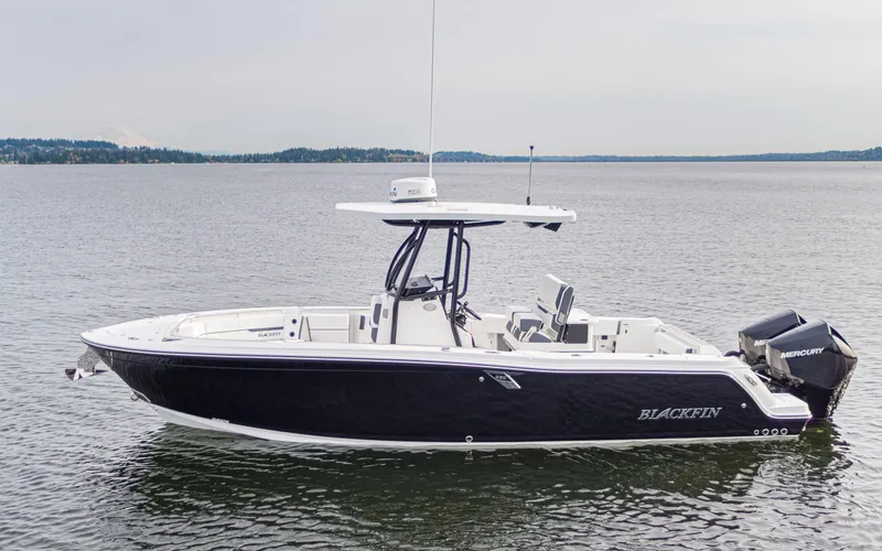 The Image of A sleek, modern boat with a black hull and white deck on calm water. - 0