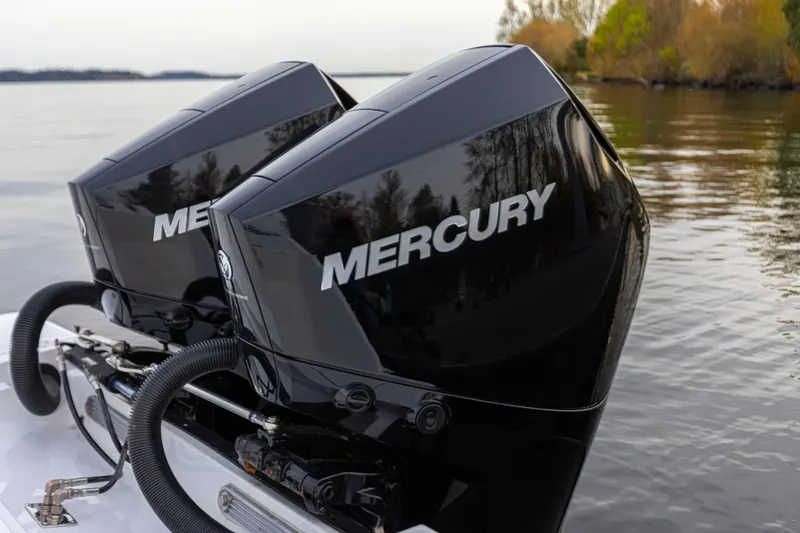 Slide: The Image of Two Mercury outboard engines are mounted on the stern of a boat on calm water. - 12