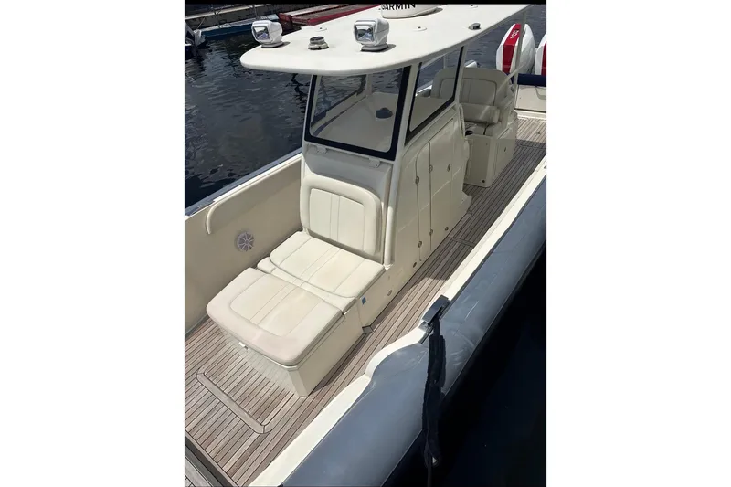 Slide: The Image of 2018 Ocean 1 R boat with cushioned seating and sleek design on the water. - 5