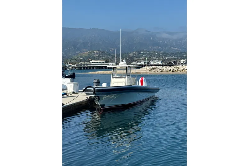 The Image of 2018 Ocean 1 R boat docked in a scenic marina with mountains in the background. - 1